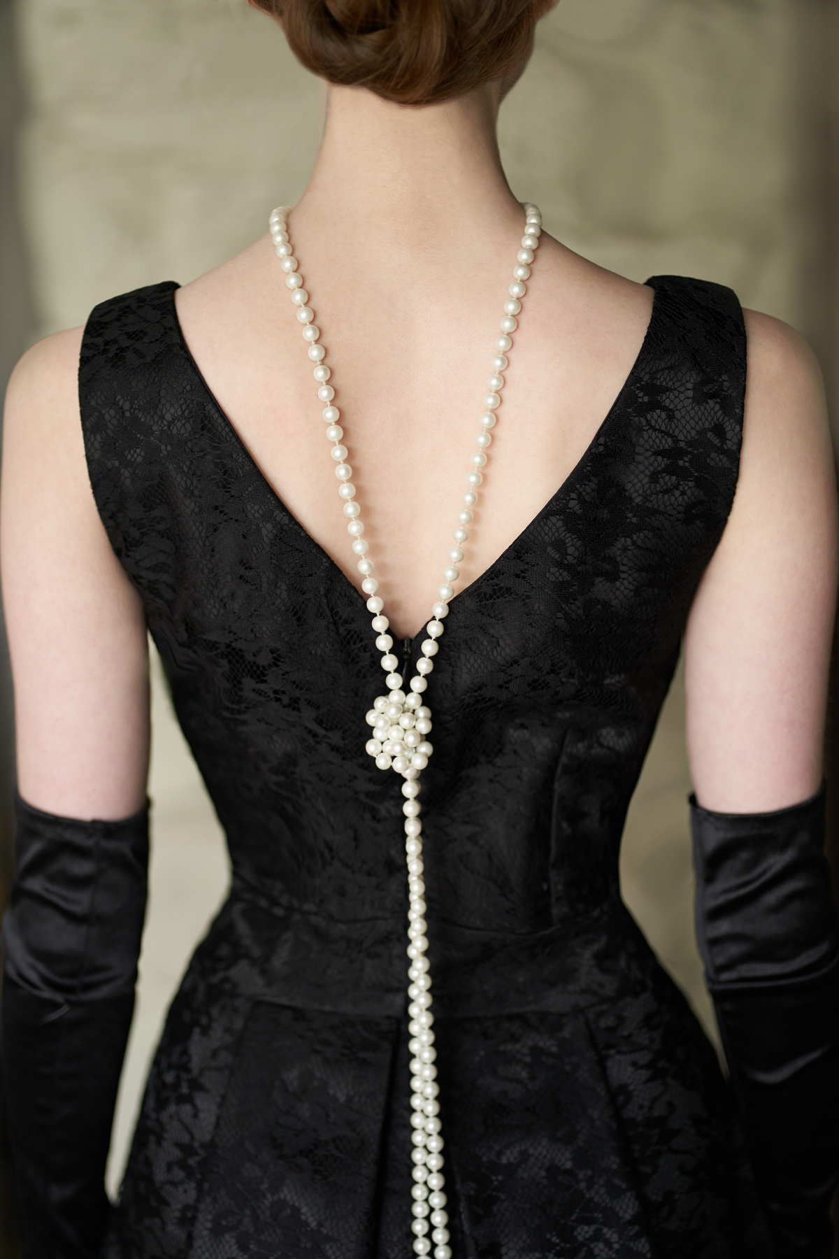 Back Detail of Woman's Black Dress and Pearl Necklace 